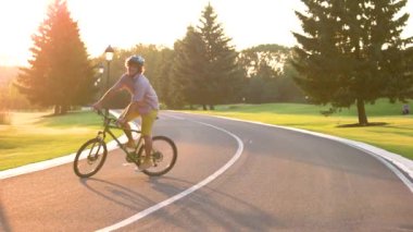 Mutlu genç öğrenci açık havada Bisiklete binme.