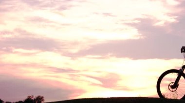 Gün batımında bisiklet ile genç insanlar.