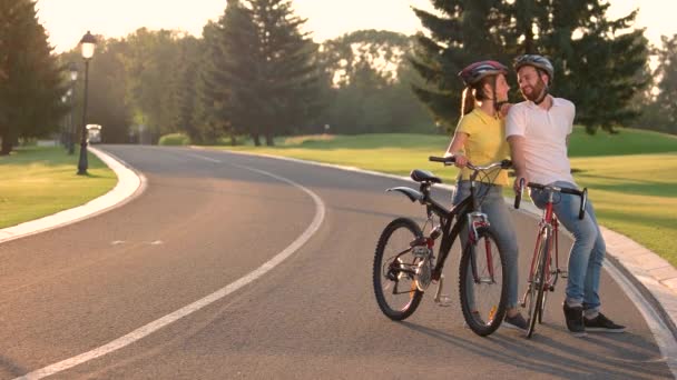 Couple de jeunes cyclistes s'embrassant sur la route . — Video