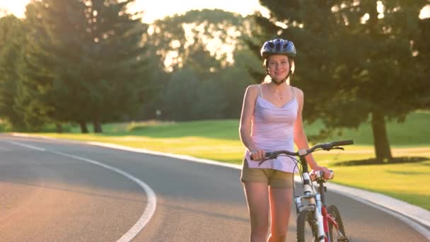 道路の上を歩いて自転車を持つ若い女性. — ストック動画