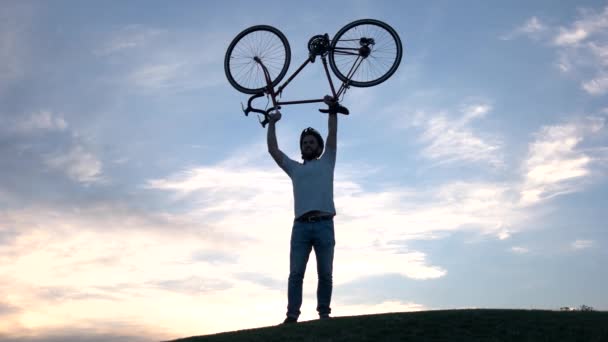 Jeune homme soulevant vélo au-dessus de la tête . — Video