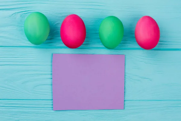 Rangée d'œufs de Pâques et carte blanche . — Photo