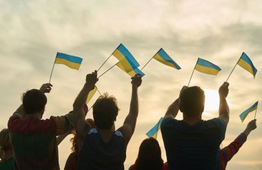 Genç sallayarak ukraininan bayrakları millet, arkadan görünüm.