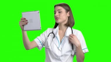 Tablet bilgisayarda çevrimiçi coversation olan genç kadın doktor.