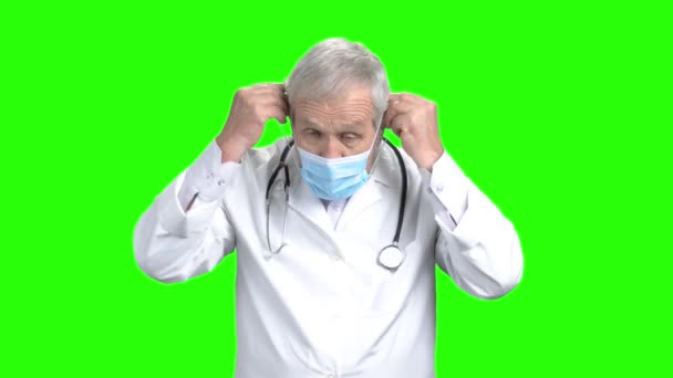 Kıdemli doktor tıbbi koruyucu maske koymak. — Stok video
