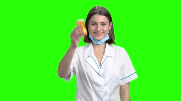 女医はオレンジの缶の丸薬を宣伝します。. — ストック動画