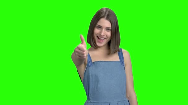 Young cute brunette girl in denim dress shows thumb up. — Stock Video