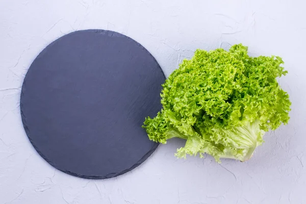 Green lettuce and natural slate board. — Stock Photo, Image