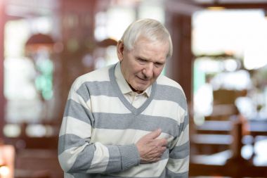 Old man holding breast because of heart infarction. clipart