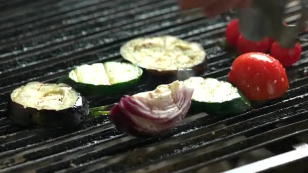 Щипцы листать овощи на гриле . — стоковое видео