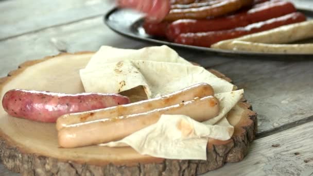 Grilled sausages on wooden board. — Stock Video