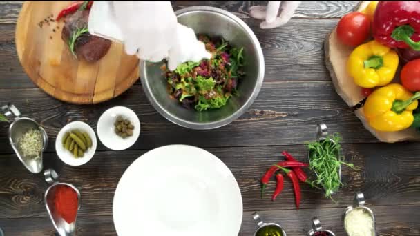 Handen voorbereiding salade, houten tafel. — Stockvideo