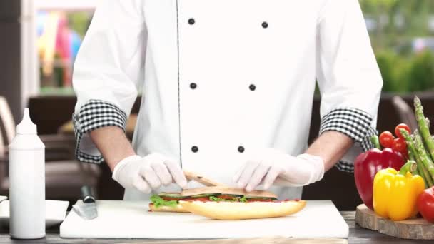 Mains de chef préparant un sandwich . — Video