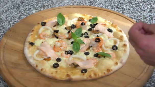 Meeresfrüchte-Pizza mit Basilikumblättern. — Stockvideo