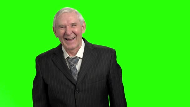 Stary człowiek w czarnym garniturze śmiejąc się twarde, zwolnionym tempie. — Wideo stockowe