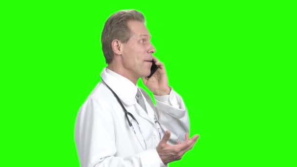 Cheerful middle-aged doctor talking on phone. — Stock Video