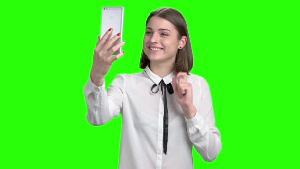 Teen girl in white blouse talking through web cam of her smartphone. — Stock Video