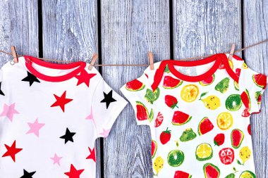 Çocuklar modern giysiler ipte asılı.