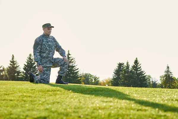 Soldat sérieux sur une pose de genou . — Photo