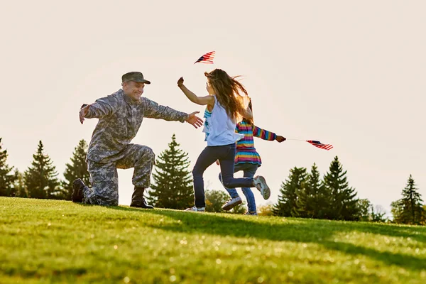 Soldado americano se encuentra con sus dos hijas al aire libre . — Foto de Stock