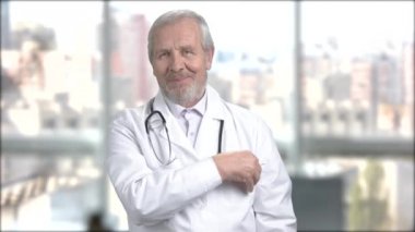 Bir boş kartı gösteren mutlu erkek doktor.