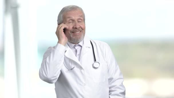 Elderly doctor talking on phone. — Stock Video