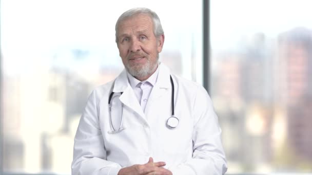 Senior bearded doctor on blurred background. — Stock Video