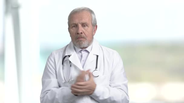 Olycklig äldre läkare, suddig bakgrund. — Stockvideo