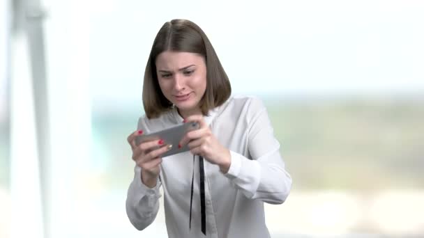 Young funny woman playing game on smartphone. — Stock Video