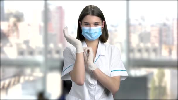Ženského lékaře klade na rukavice. — Stock video