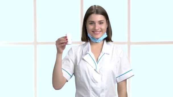 Jovem enfermeira sorridente segurando pílulas . — Vídeo de Stock