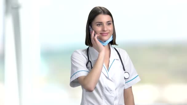 Young female doctor talking on phone. — Stock Video