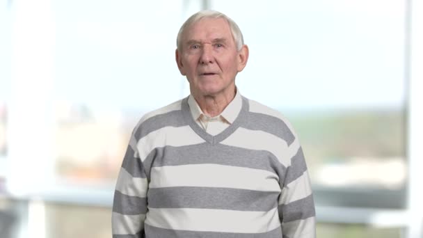 Irritated elderly man, blurred background. — Stock Video