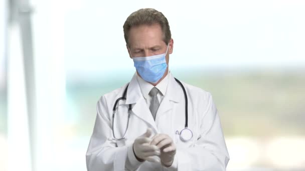 Dokter zetten handschoenen, dan vouw handen en armen. — Stockvideo