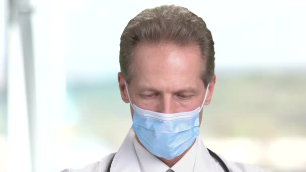 A cara fechada de um doutor na máscara olha para baixo . — Vídeo de Stock