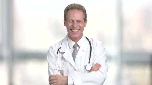Mature doctor laughing on blurred background. — Stock Video