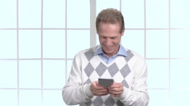 Neşeli adam onun smarthone üzerinde oyun oynama.