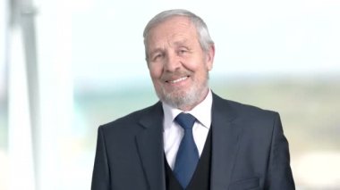 Neşeli üst düzey iş adamı, arka plan bulanık.