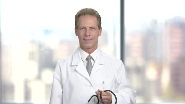 Male doctor putting on stethoscope. — Stock Video
