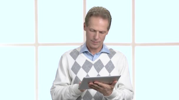 Positive middle-aged man working on pc tablet. — Stock Video