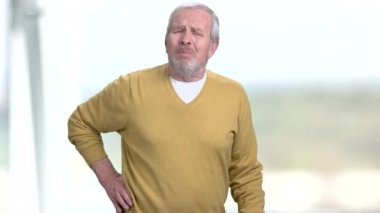 Yaşlı adam sırt ağrısı çekiyor.