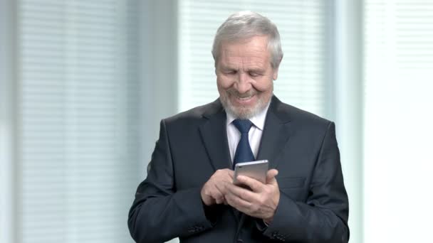 Hombre de negocios anciano enviando un mensaje de texto . — Vídeo de stock