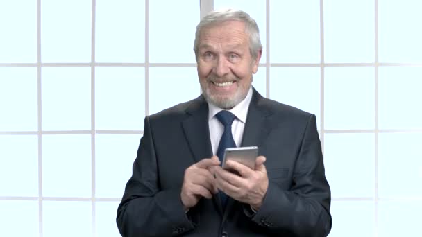 Happy elderly businessman with smartphone. — Stock Video