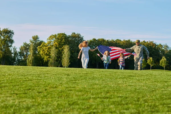 Familia patriótica con enormes banderas de EE.UU. al aire libre . — Foto de Stock