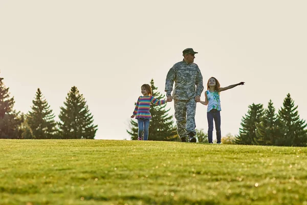 Soldado y sus hijas en la hierba . — Foto de Stock