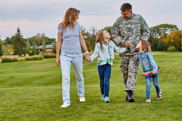 Familia feliz con padre soldado caminando al aire libre . — Foto de Stock