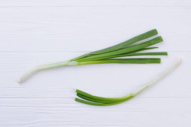Beyaz ahşap üzerine genç yeşil soğan.