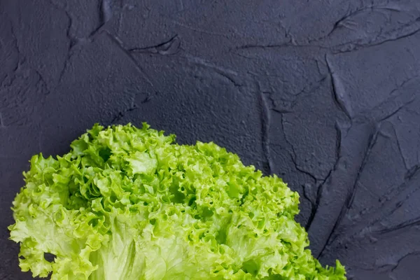 Свежий зеленый салат на черной доске . — стоковое фото