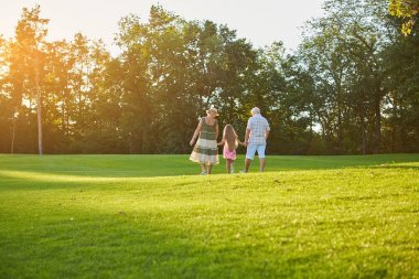 Yeşil çimenlerin üzerinde yürüyüş insanlar.