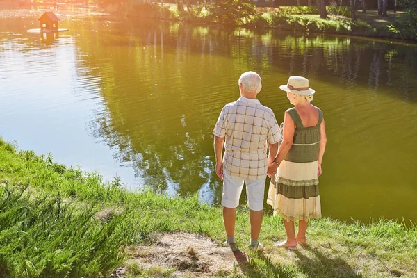 Seniorenpaar steht am Wasser. — Stockfoto